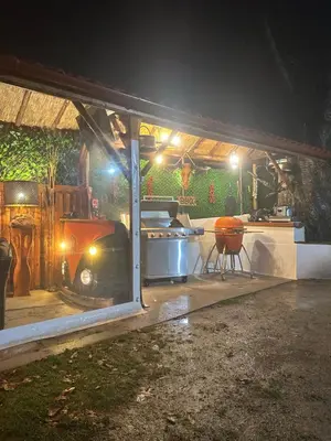 a kitchen with a grill in a garage at night at Къща за гости Падалото in Smolyan