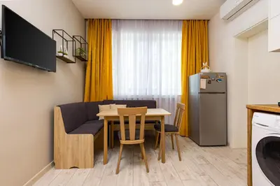a kitchen and dining room with a table and a refrigerator at Maritsa 1BD Apartment by Flat Manager in Plovdiv