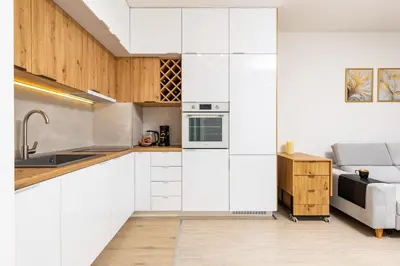 a kitchen with white cabinets and a couch at Magnolia Gardens -1BD with Balcony & Parking by Flat Mаnager in Plovdiv