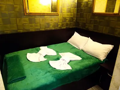 a green bed with three folded towels on it at Apartment Lion's bridge 1 - Top Center in Sofia