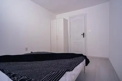 a bedroom with a bed and a white door at Студио Черно и Бяло in Sandanski