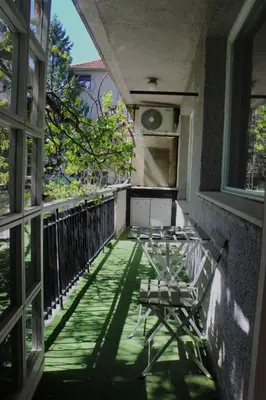 a balcony with two chairs and a window at Apartment Near NDK Biairbnb in Sofia