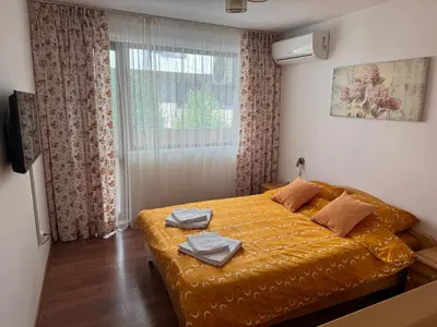 a bedroom with a bed with yellow sheets and a window at United Apartments 3 in Sandanski