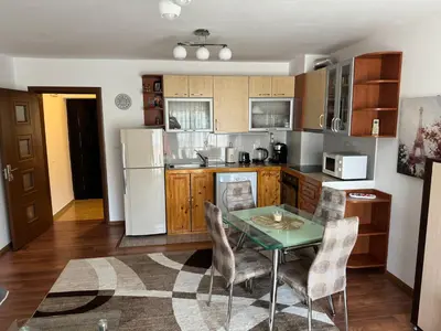 a kitchen with a table and a refrigerator at United Apartments 3 in Sandanski