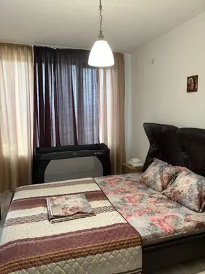 a bedroom with a bed with a quilt on it at Трушеви in Sandanski