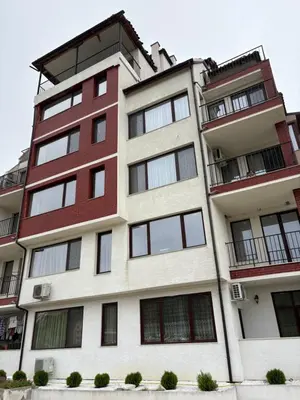 a tall apartment building with red and white at Трушеви in Sandanski