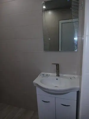 a white bathroom with a sink and a mirror at Трушеви in Sandanski