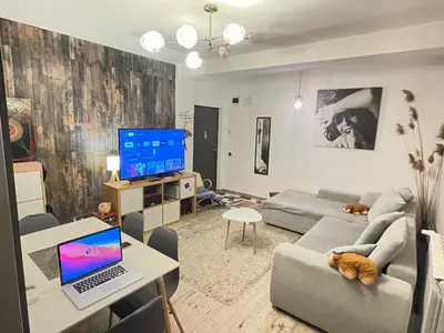 a living room with a couch and a laptop on a table at Bulg Modern in Sofia