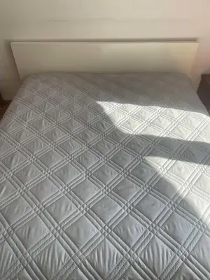 a bed with a white bedspread on top of it at Park Residence in Sofia