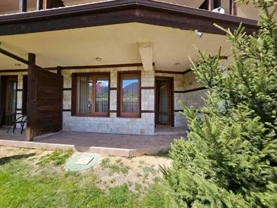 a house with a porch with windows and a patio at Luxury apartment in Downtown Resort Bansko in Bansko