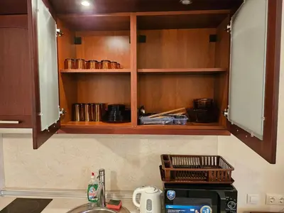 a kitchen counter with wooden cabinets and a microwave at Luxury apartment in Downtown Resort Bansko in Bansko