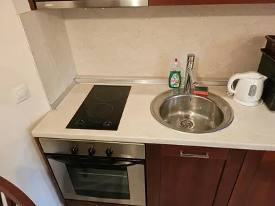 a kitchen counter with a sink and a stove and a sinkktop at Luxury apartment in Downtown Resort Bansko in Bansko