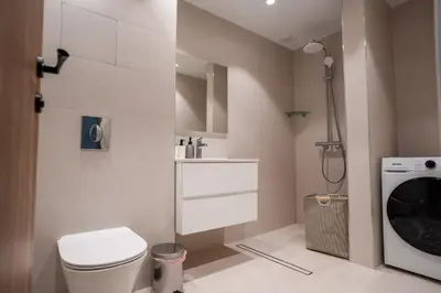 a bathroom with a toilet and a washer and dryer at Stylish Apartment in City Center in Sofia