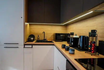 a kitchen with white cabinets and a counter top at Stylish Apartment in City Center in Sofia