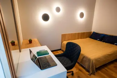 a small room with a bed and a laptop on a desk at Stylish Apartment in City Center in Sofia