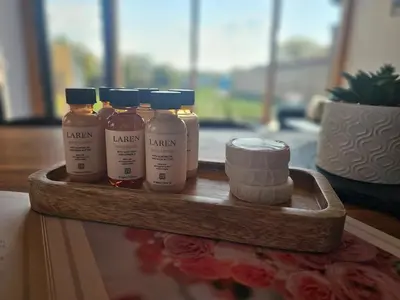 a wooden tray with four bottles of kenyan products at Villa Selya - Private Pool & Mountain View in Selyanin