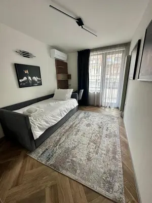 a bedroom with a bed and a rug at Milea apartments in Sofia