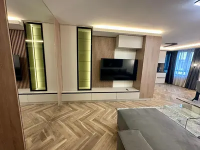a living room with a flat screen tv and a living room with wooden floors at Milea apartments in Sofia