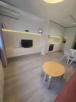 a living room with a table and a tv at Paradise Stay & private parking in Sofia