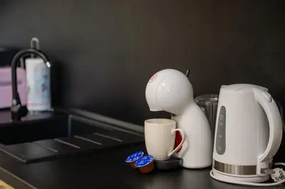 a kitchen counter with a coffee maker and a cup at Luminous 2BDR with Balcony & View in the center in Sofia
