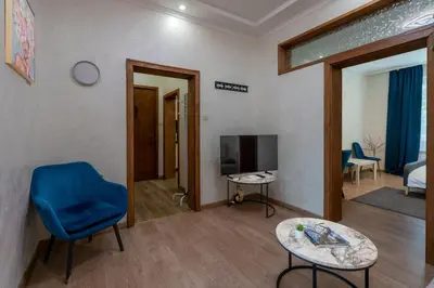 a living room with a blue chair and a tv at Luminous 2BDR with Balcony & View in the center in Sofia