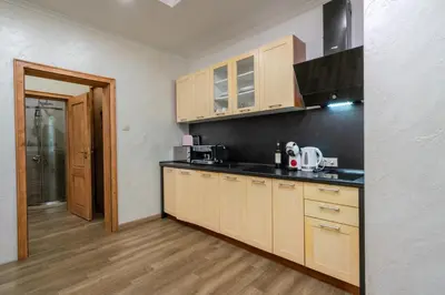 a kitchen with wooden cabinets and a black counter top at Luminous 2BDR with Balcony & View in the center in Sofia