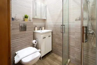 a bathroom with a toilet and a sink and a shower at Luminous 2BDR with Balcony & View in the center in Sofia