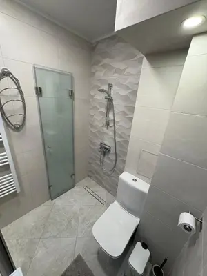 a white bathroom with a shower and a toilet at Nikea apart 1 in Velingrad