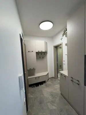 a kitchen with white cabinets and a table in a room at Nikea apart 1 in Velingrad