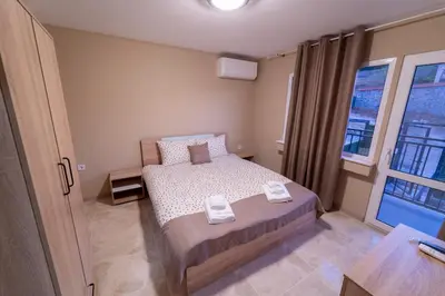 a small bedroom with a bed and a window at Къща за гости Катлея in Hisarya
