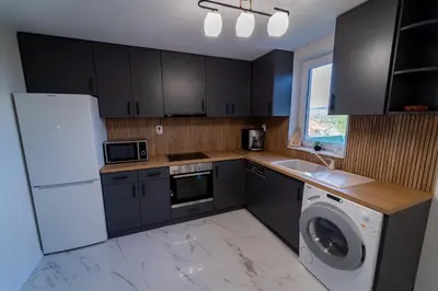 a kitchen with a white refrigerator and a dishwasher at Къща за гости Катлея in Hisarya
