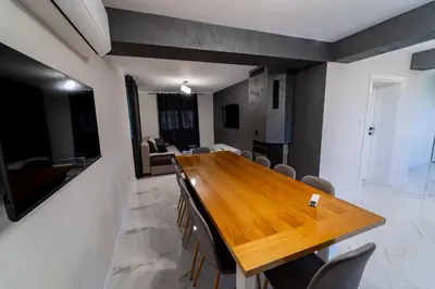 a dining room with a wooden table and chairs at Къща за гости Катлея in Hisarya