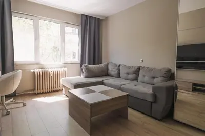 a living room with a couch and a tv at Iztok House Apartment in Sofia