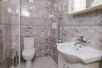 a bathroom with a white toilet and a sink at Iztok House Apartment in Sofia