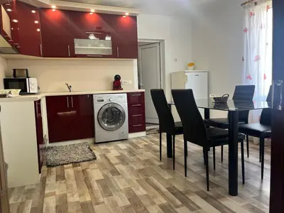 a kitchen and dining room with a table and a washing machine at Речен шепот in Kalofer