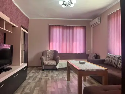 a living room with a chair and a table at Речен шепот in Kalofer