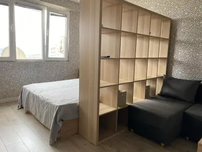 a bedroom with a bed and a book shelf at Панорама in Panagyurishte