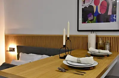 a wooden table with two white plates and candles on it at Oblivion in Velingrad