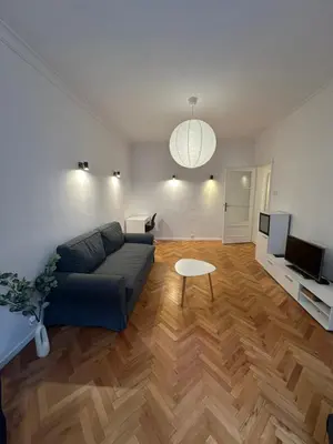 a living room with a blue couch and a table at Apartament 151 in Sofia