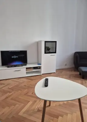 a living room with a white table and a tv at Apartament 151 in Sofia