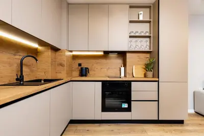 a kitchen with white cabinets and a sink at 1BR Modern and Cozy Apartment with Free Street Parking in Plovdiv