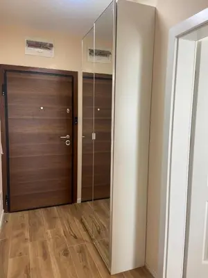 a hallway with a wooden door and a glass closet at Sofia Park View Apartment in Sofia