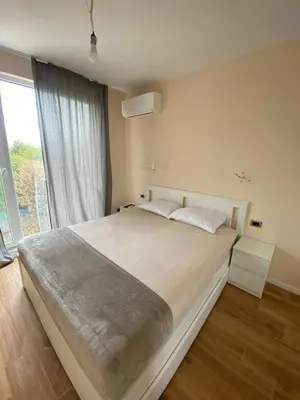 a bedroom with a large bed with a large window at Sofia Park View Apartment in Sofia