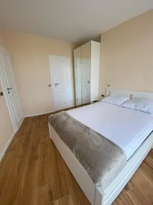 a bedroom with a large white bed with wooden floors at Sofia Park View Apartment in Sofia