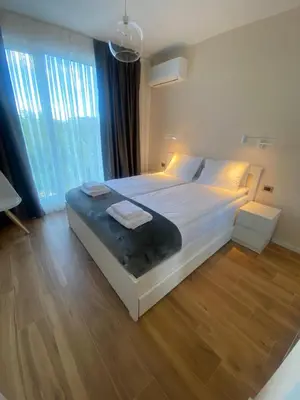 a bedroom with a large bed and a large window at Sofia Park View Apartment in Sofia