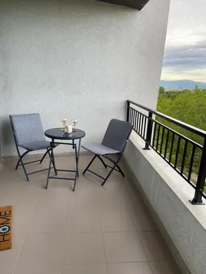 two chairs and a table on a balcony with a view at Sofia Park View Apartment in Sofia