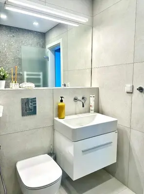 a bathroom with a sink and a toilet and a mirror at Апартамент В 48 в Сграда МОНА in Sofia