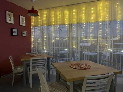a dining room with tables and chairs and a window at Villa YoSi - apartments in Sapareva Banya