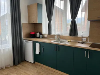 a kitchen with green cabinets and a sink and a window at Villa YoSi - apartments in Sapareva Banya