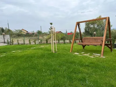 a park with a bench in the grass at Villa YoSi - rooms in Sapareva Banya